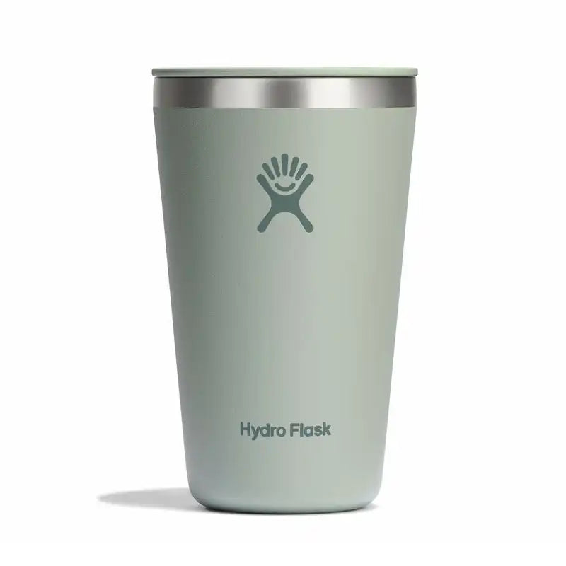 A Hydro Flask travel tumbler in a muted sage green color with a stainless steel rim and the classic Hydro Flask logo on the front