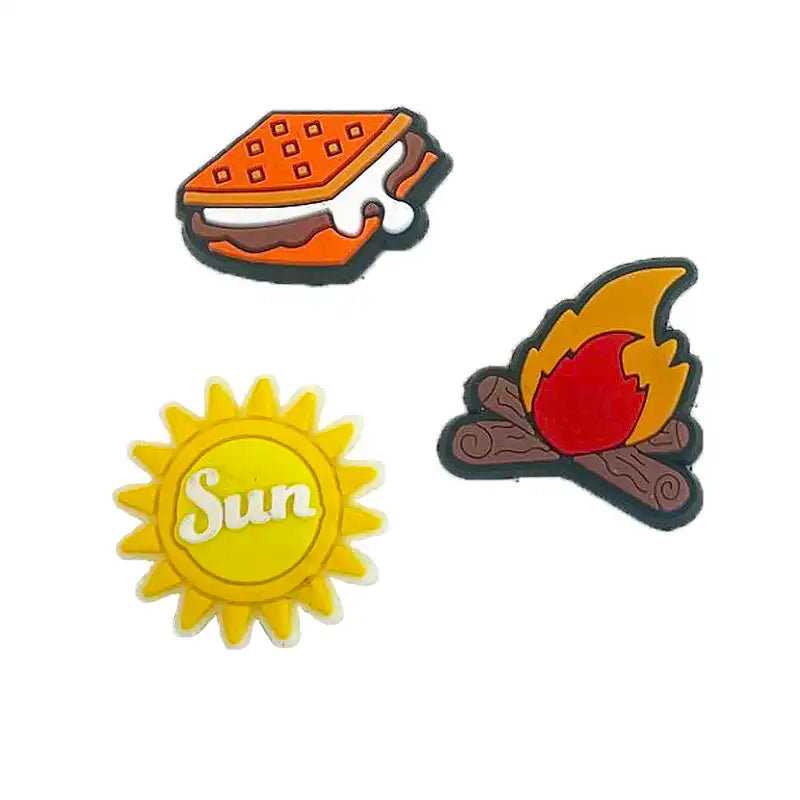 Three colorful Sippety Charms featuring a s'more, sun, and campfire